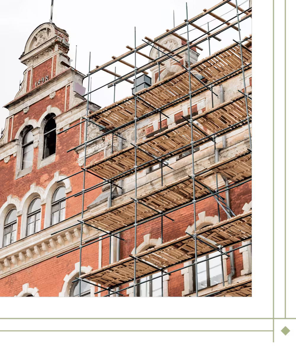 Multi-story brick building under construction with scaffolding